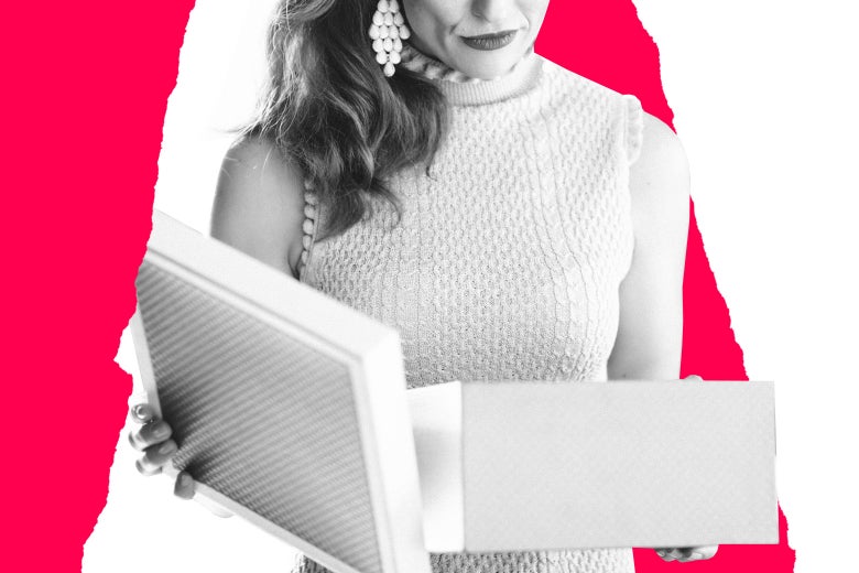 A woman opens a gift box while pursing her lips, seemingly in disapproval.